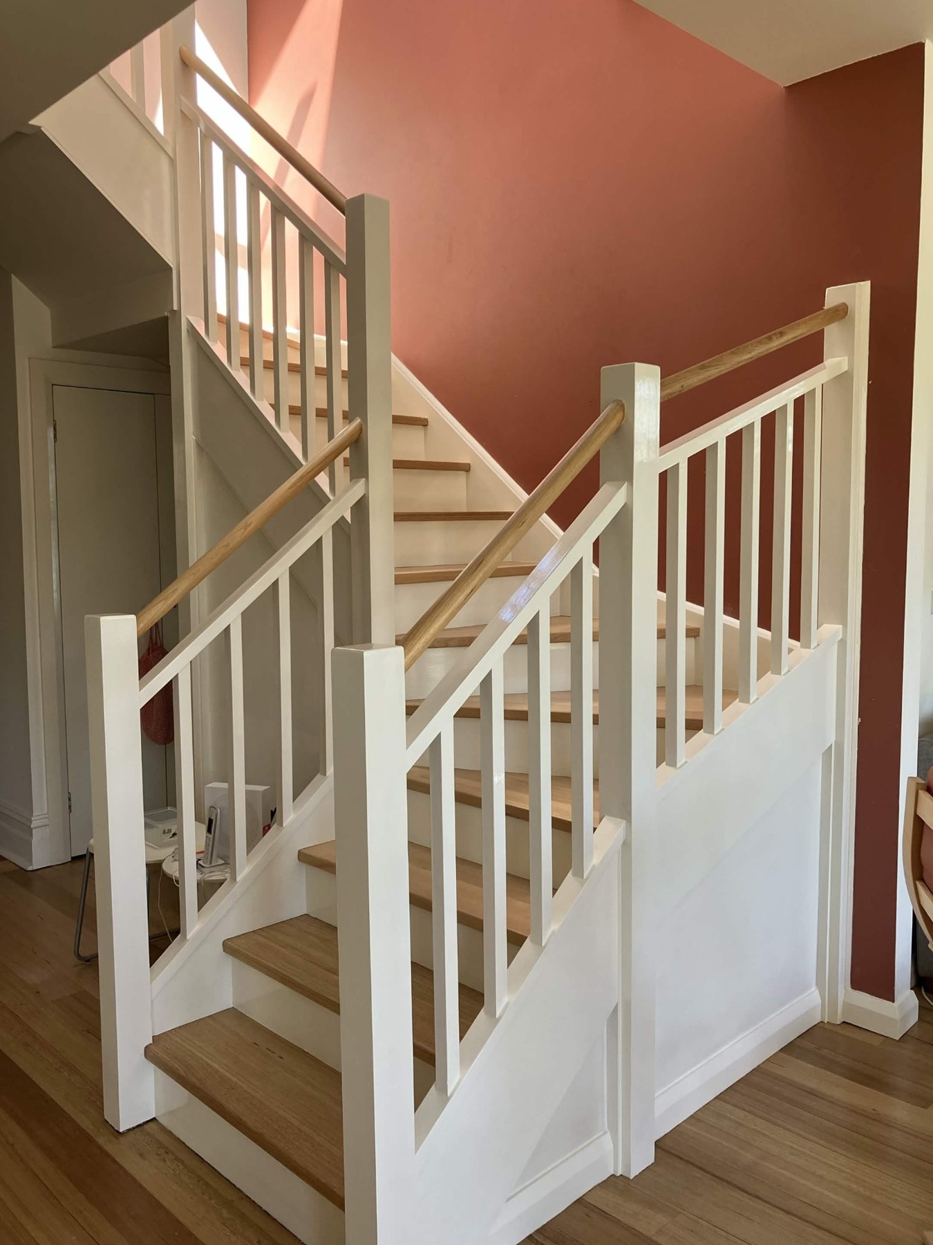 Updated staircase with white balustrades and timber treads